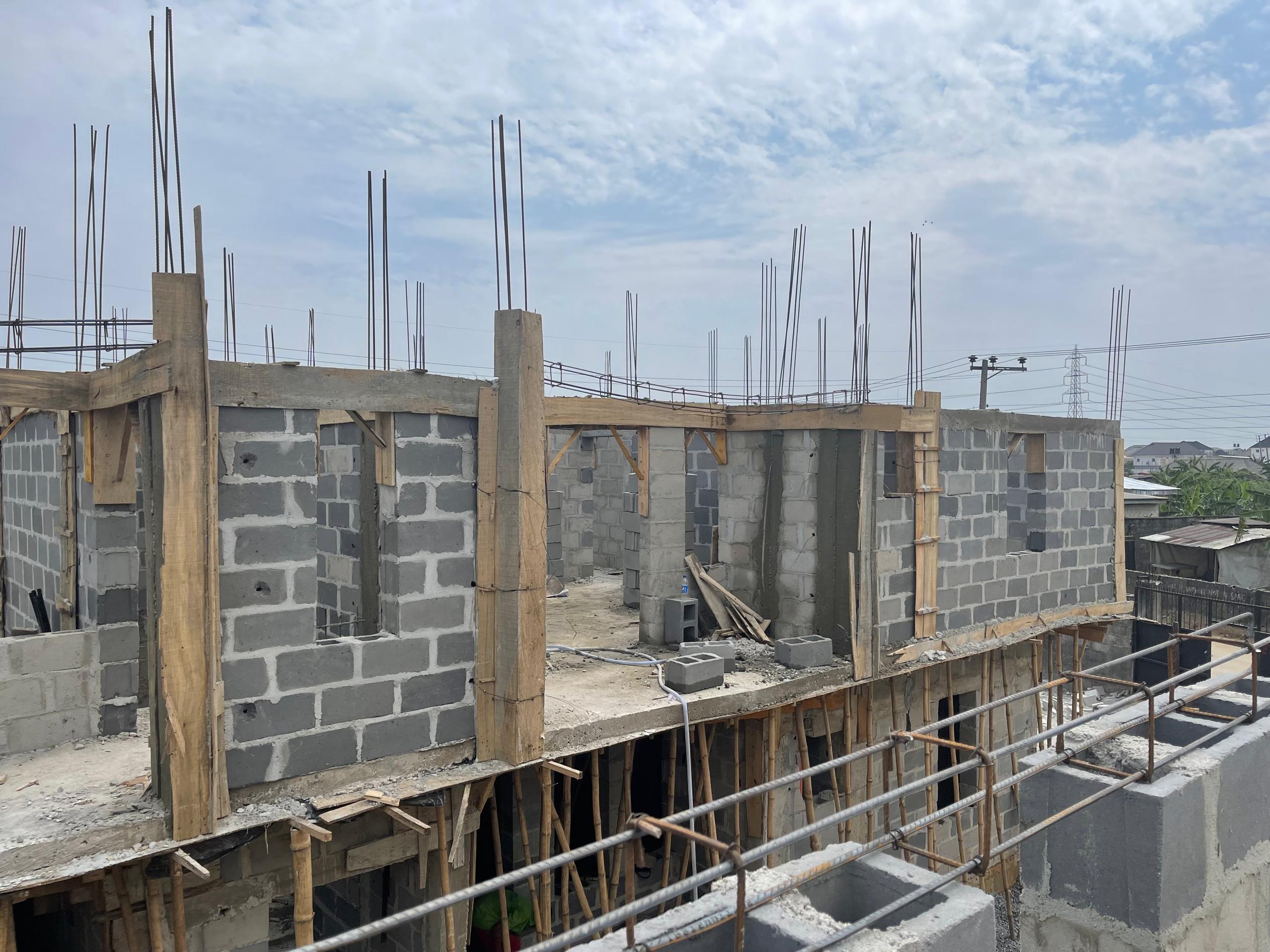 Concrete columns and structural framing rising on a construction site.